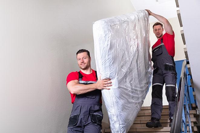 heavy lifting of a box spring during home renovation in Alviso